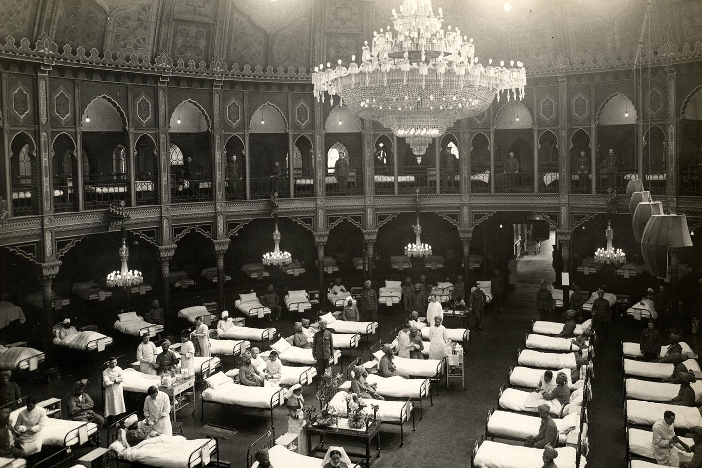 patients lined up in beds in an old hospital